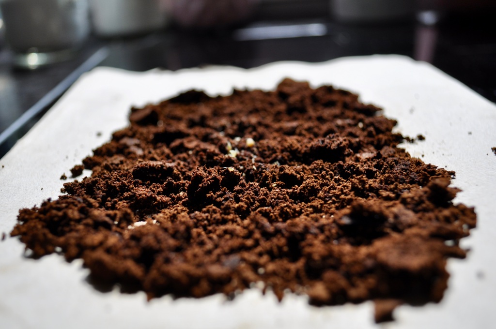 Image showing spent coffee grounds spread out on paper to dry.